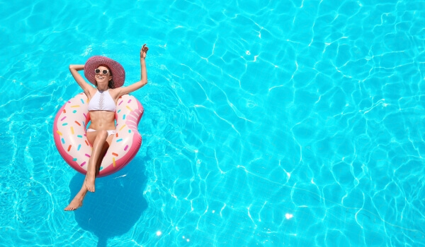 Women lounging in a pool on a inflated donut