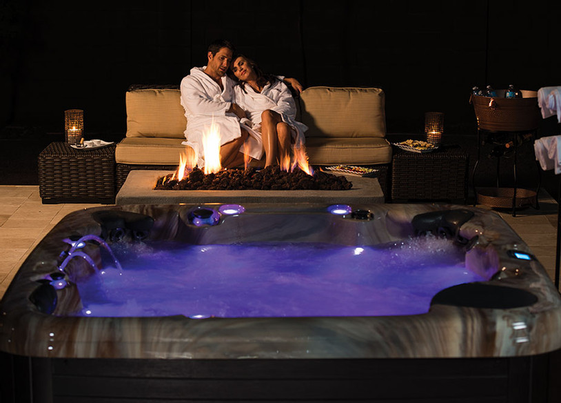 Couple in robes looking at their hot tub